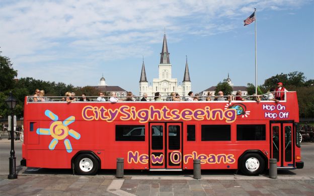 Bright red city sightseeing Hop-on Hop-off bus in New Orleans: Excited tourists embark on their thrilling ride through the vibrant city.